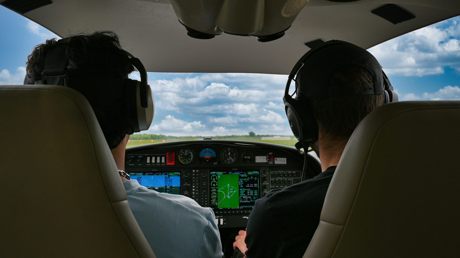 Instructor and student seen from the back seat during a flight