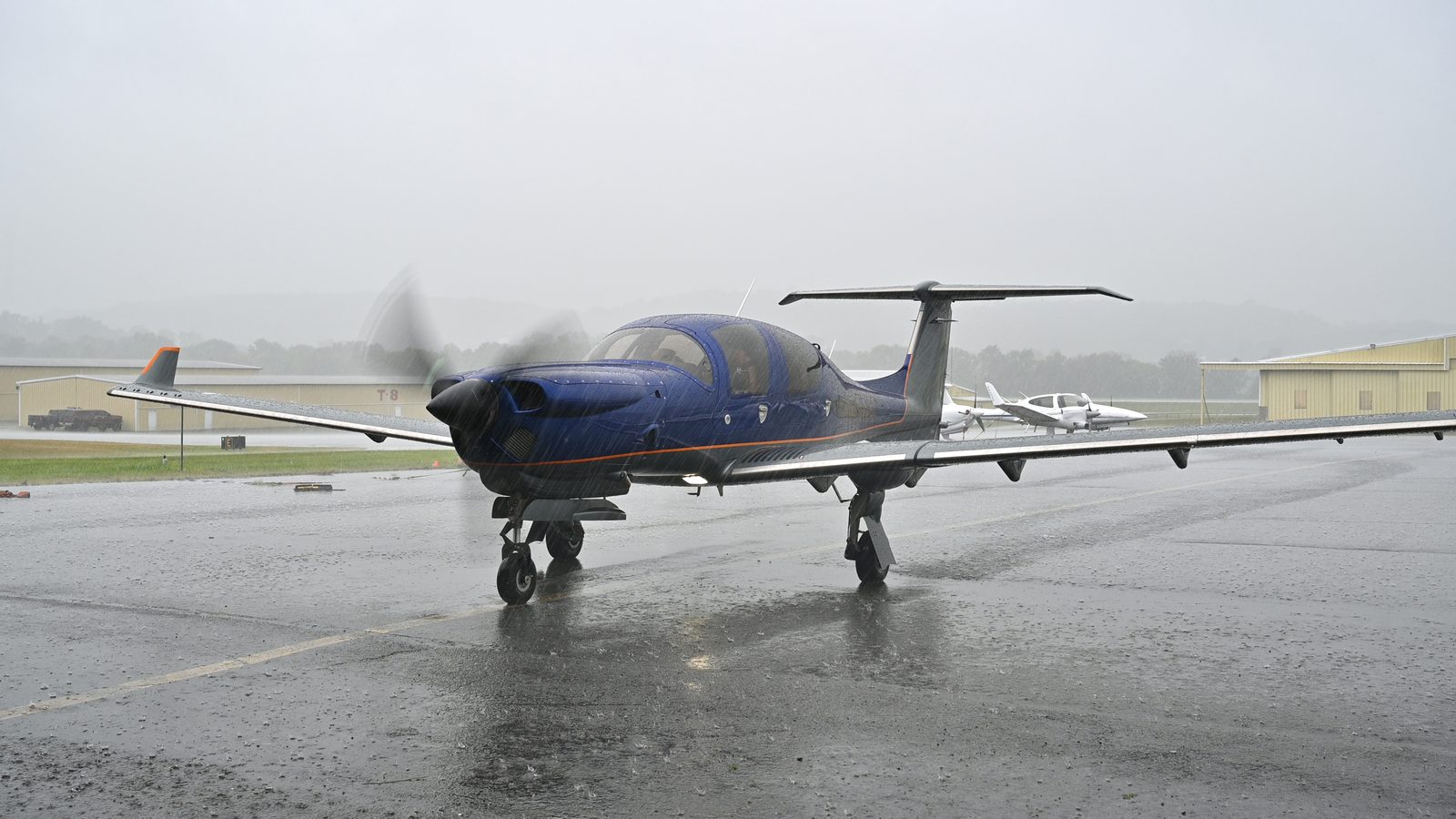 Single-engine Diamond taxiing on a wet ramp in the rain