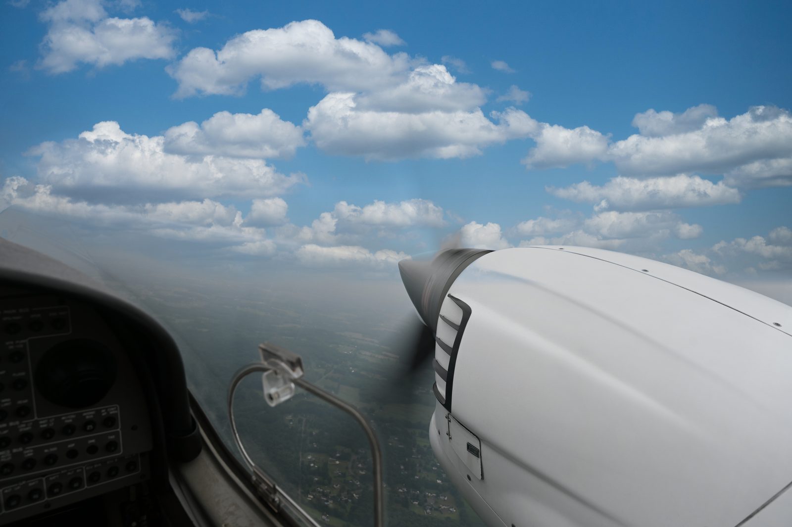 Diamond aircraft propeller and cowling above a sea of clouds