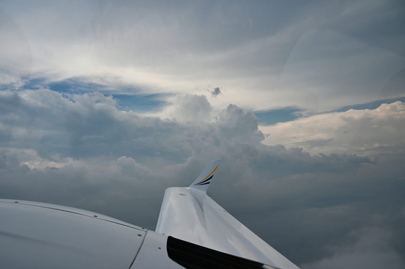 Wingtip over broken clouds at altitude