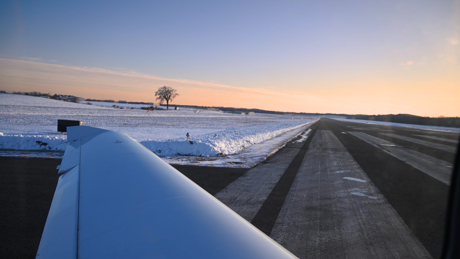 Wing and runway centerline on a cold winter evening
